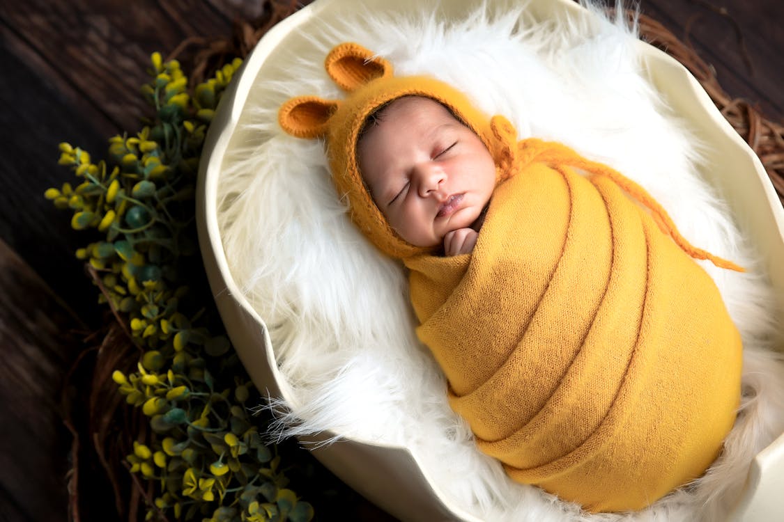 Baby in Yellow Blanket and Hat Sleeping Free Stock Photo