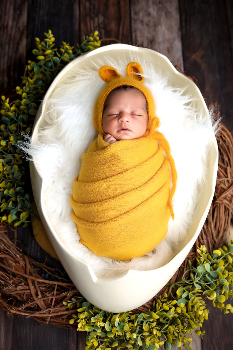 A Little Baby Sleeping In A Yellow Blanket