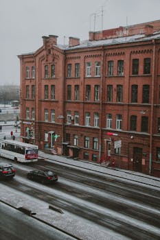 白雪覆盖的街道上，红砖建筑林立，车流与行人往来穿梭