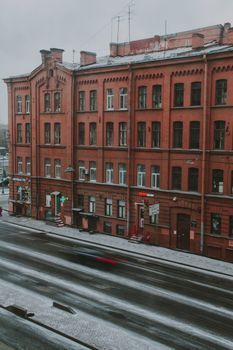 A red brick building with a frosty facade and street view during winter.