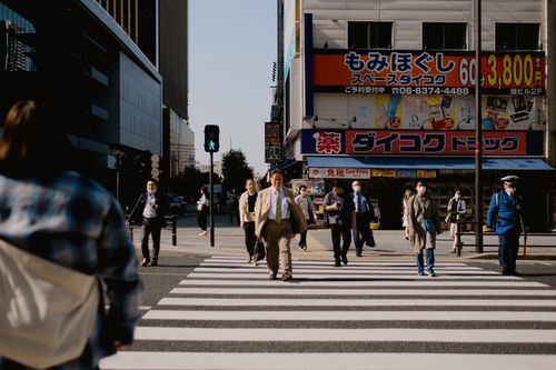 Free A bustling city intersection in Japan with diverse pedestrians crossing a zebra crossing. Stock Photo