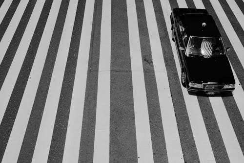 High Angle Shot of a Black Car on at a Zebra Crossing in City 