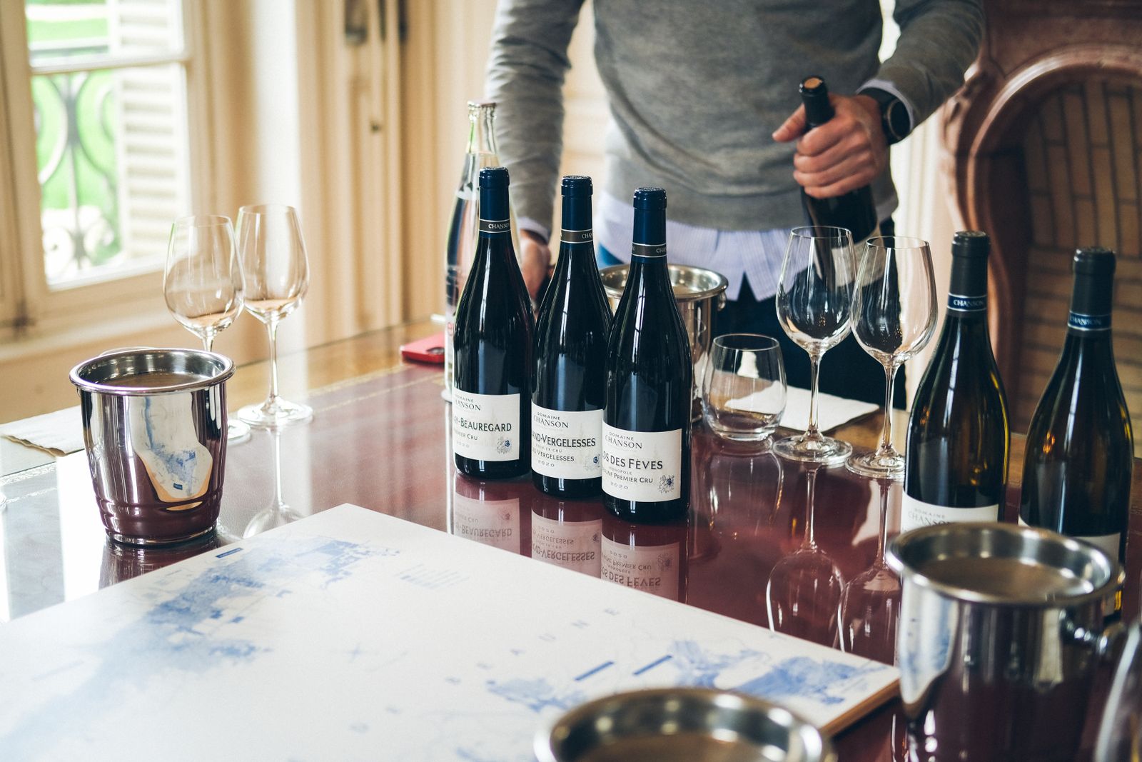 A sommelier pouring wine into glasses at a tasting table