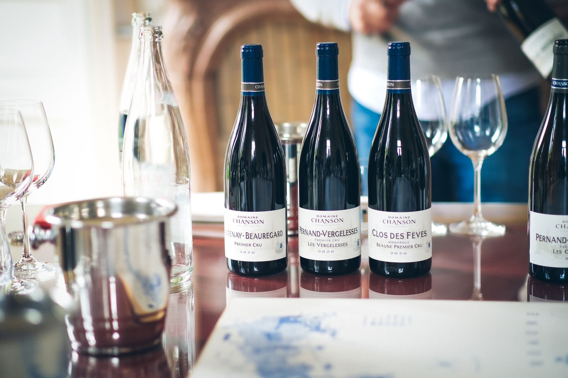 Elegant wine tasting setup in Beaune, featuring French wine bottles and glasses on a table.