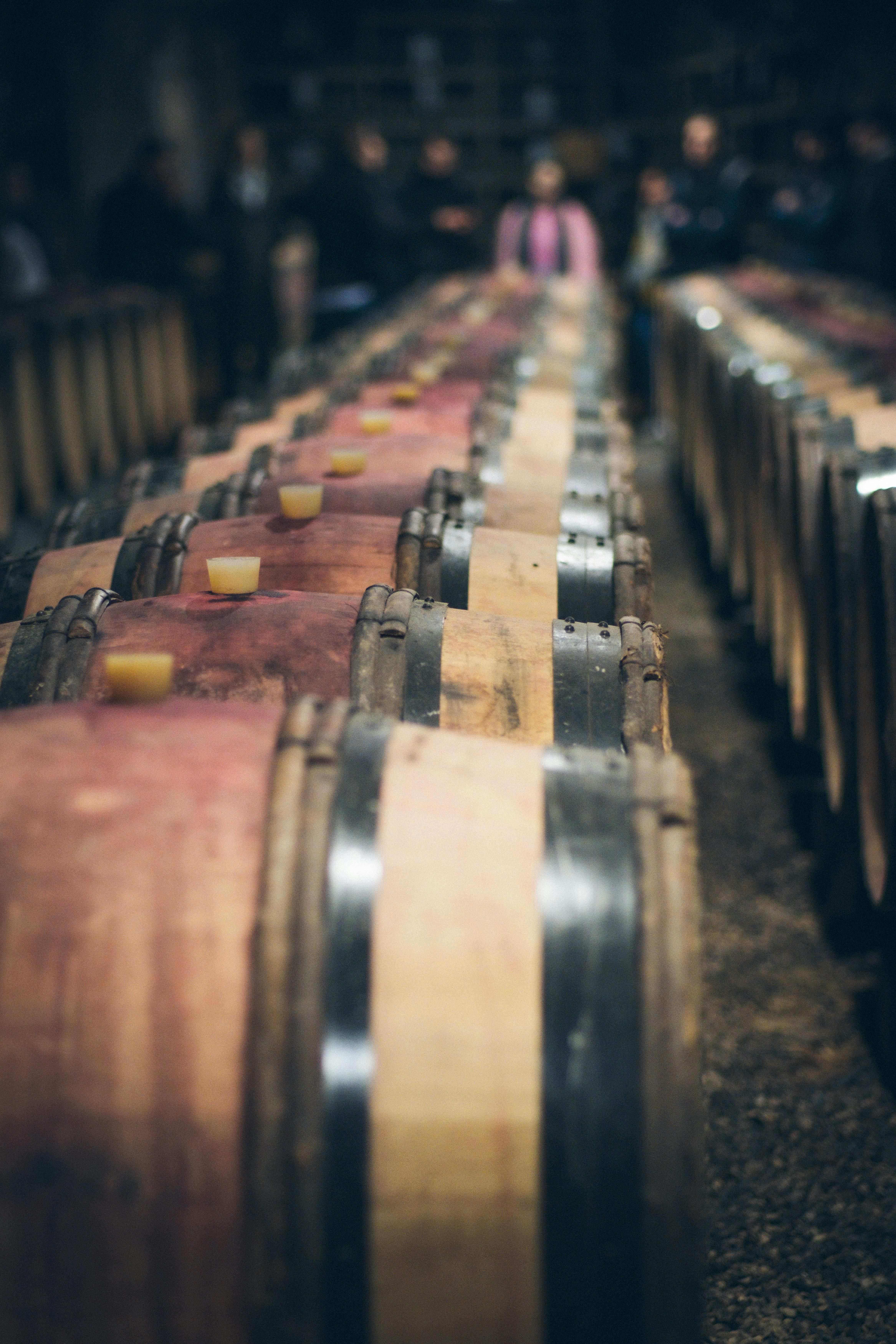 Close-up of wooden wine barrels lined up in a cellar, perfect for aging wine.
