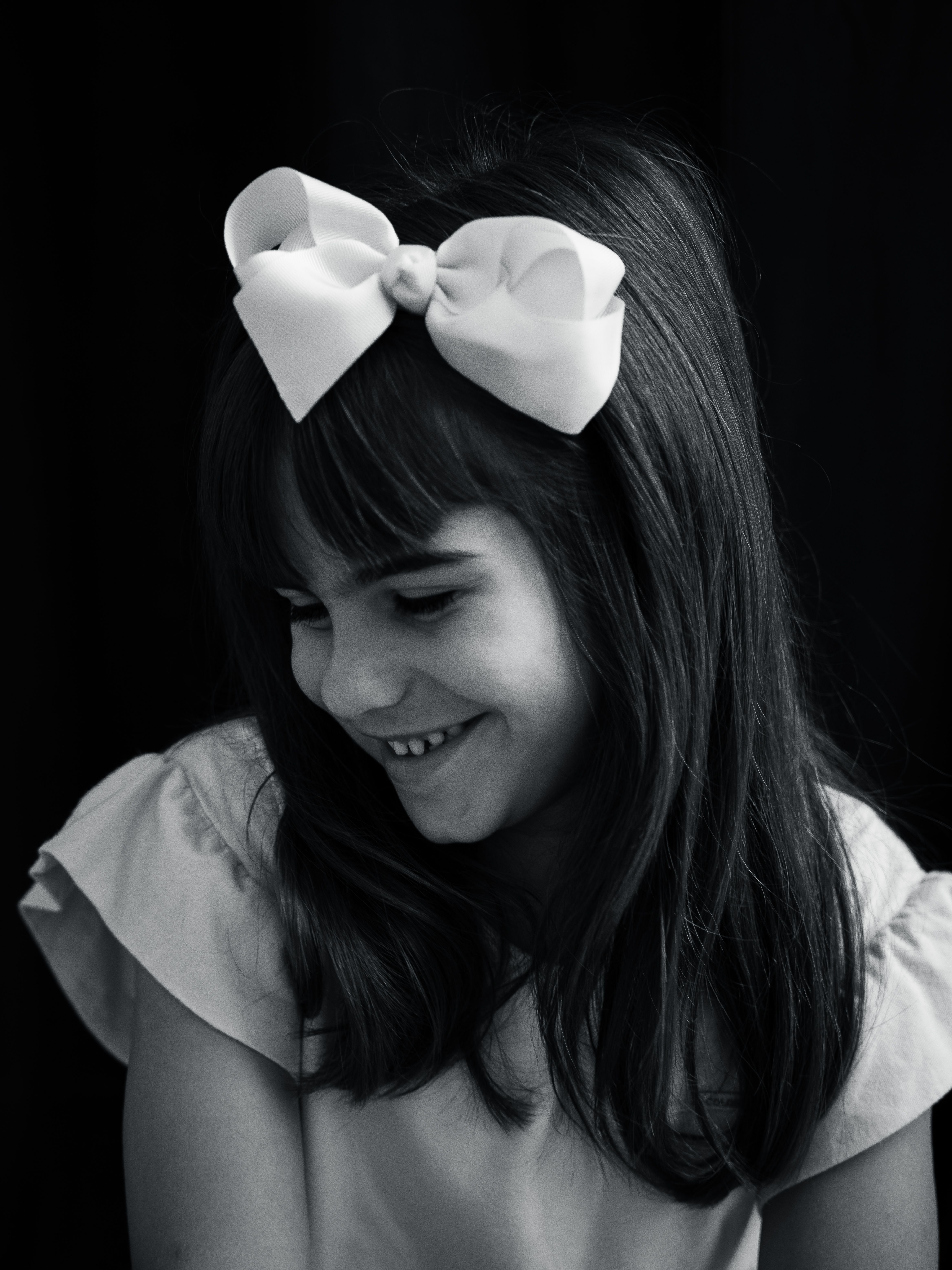 A Portrait of a Girl Wearing Bow in Black and White · Free Stock Photo