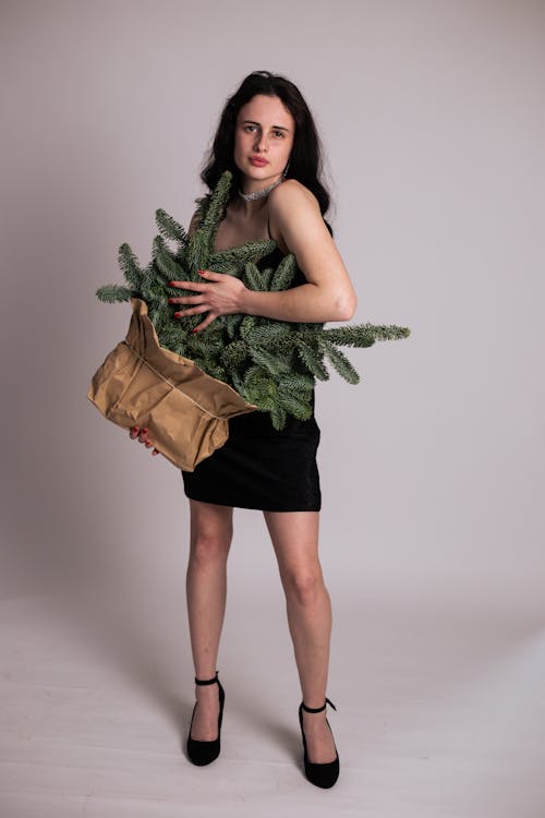 Woman Posing with Christmas Tree in Bag