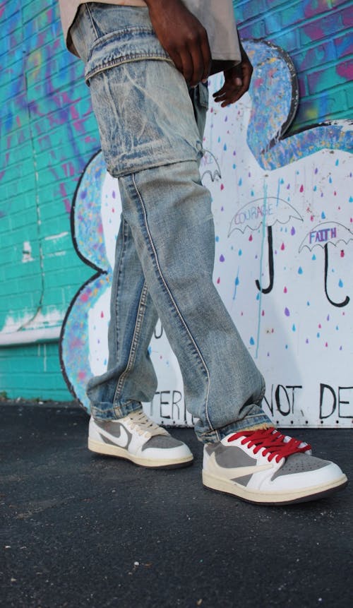 Legs of a Man Wearing Jeans and Sneakers