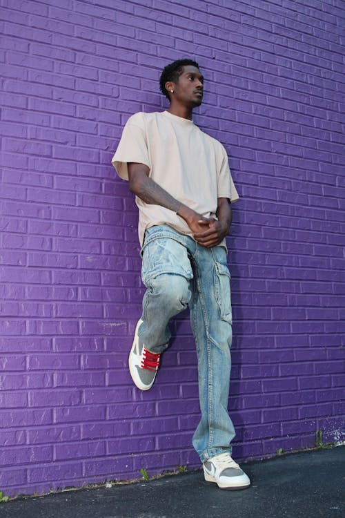 Male Model Leaning on a Purple Brick Wall