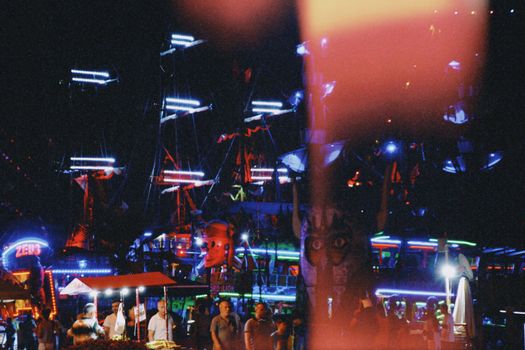 A lively night at a Turkish fairground with illuminated rides and people enjoying the atmosphere.