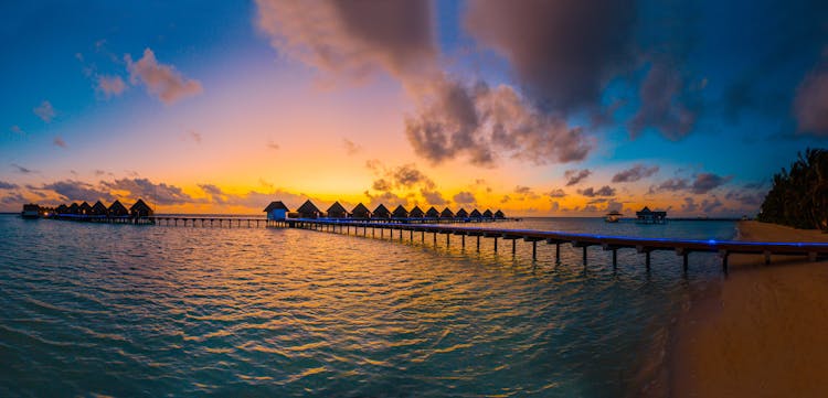 Silhouette Photography Of In-lined Cottages In Sea