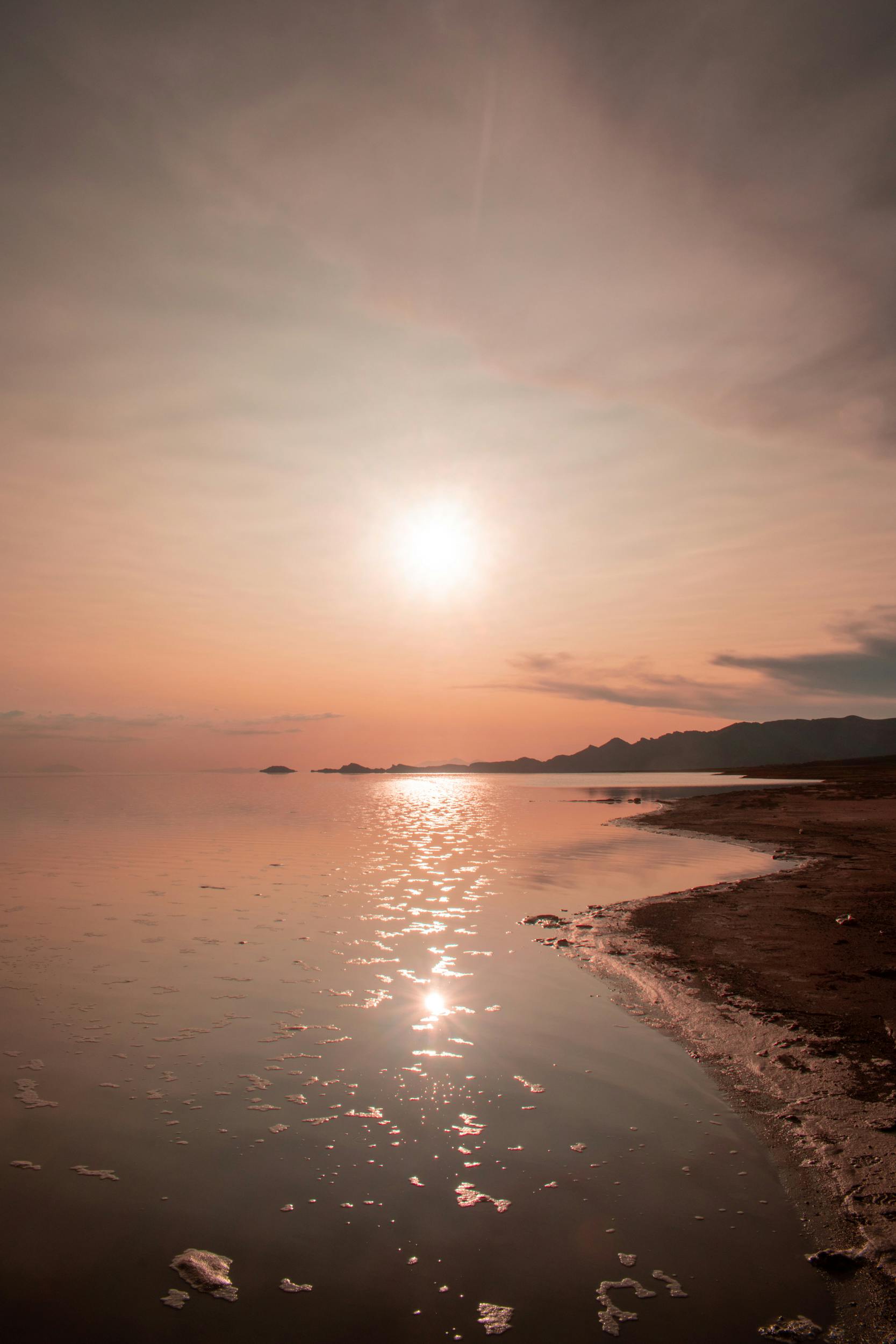 Serene sunrise over a tranquil lake in Uyuni, Bolivia, capturing the peaceful reflection and vast landscape.
