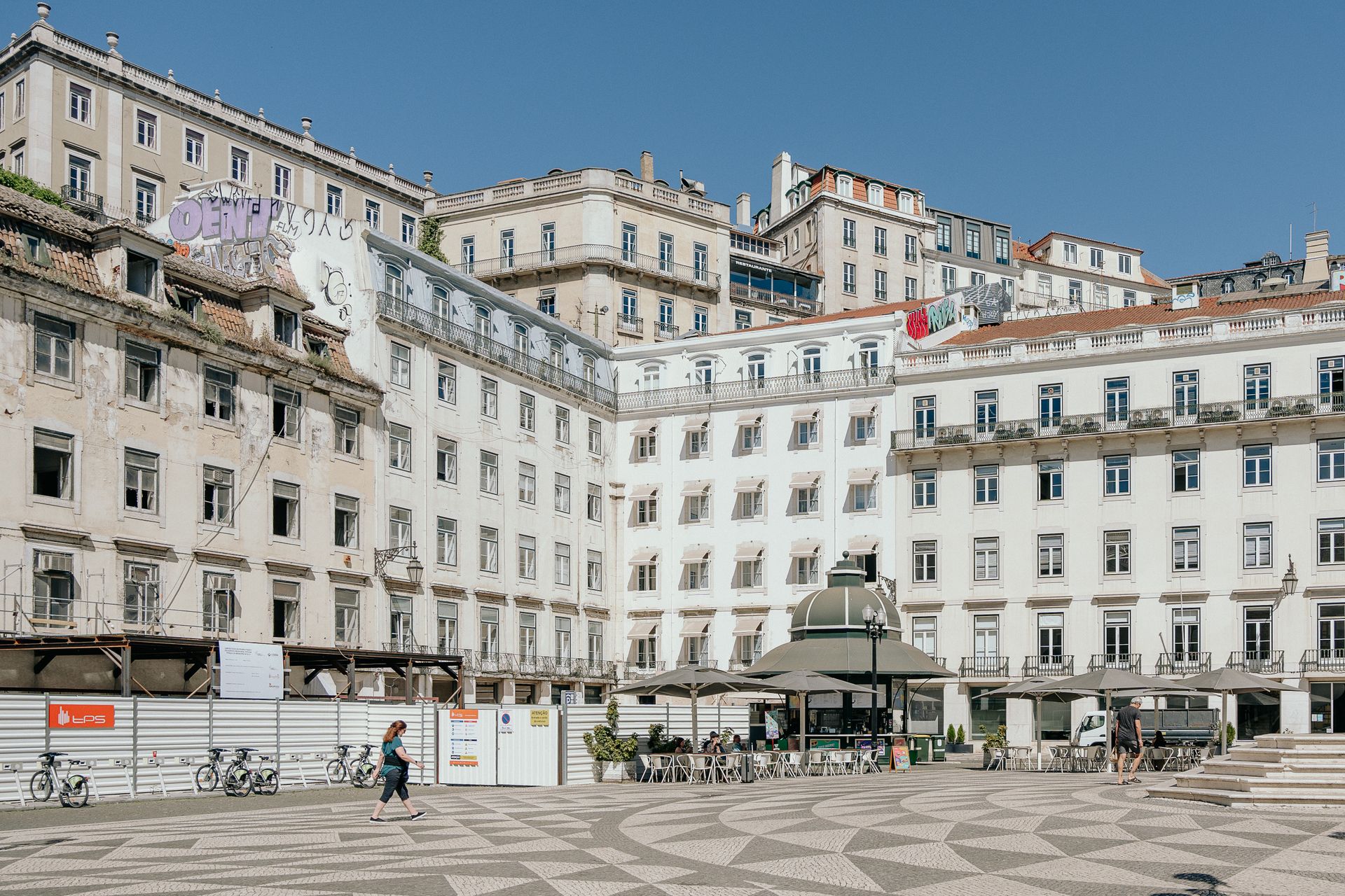 A vibrant cityscape featuring local landmarks and a bustling sidewalk cafe in Lisbon, Portugal.