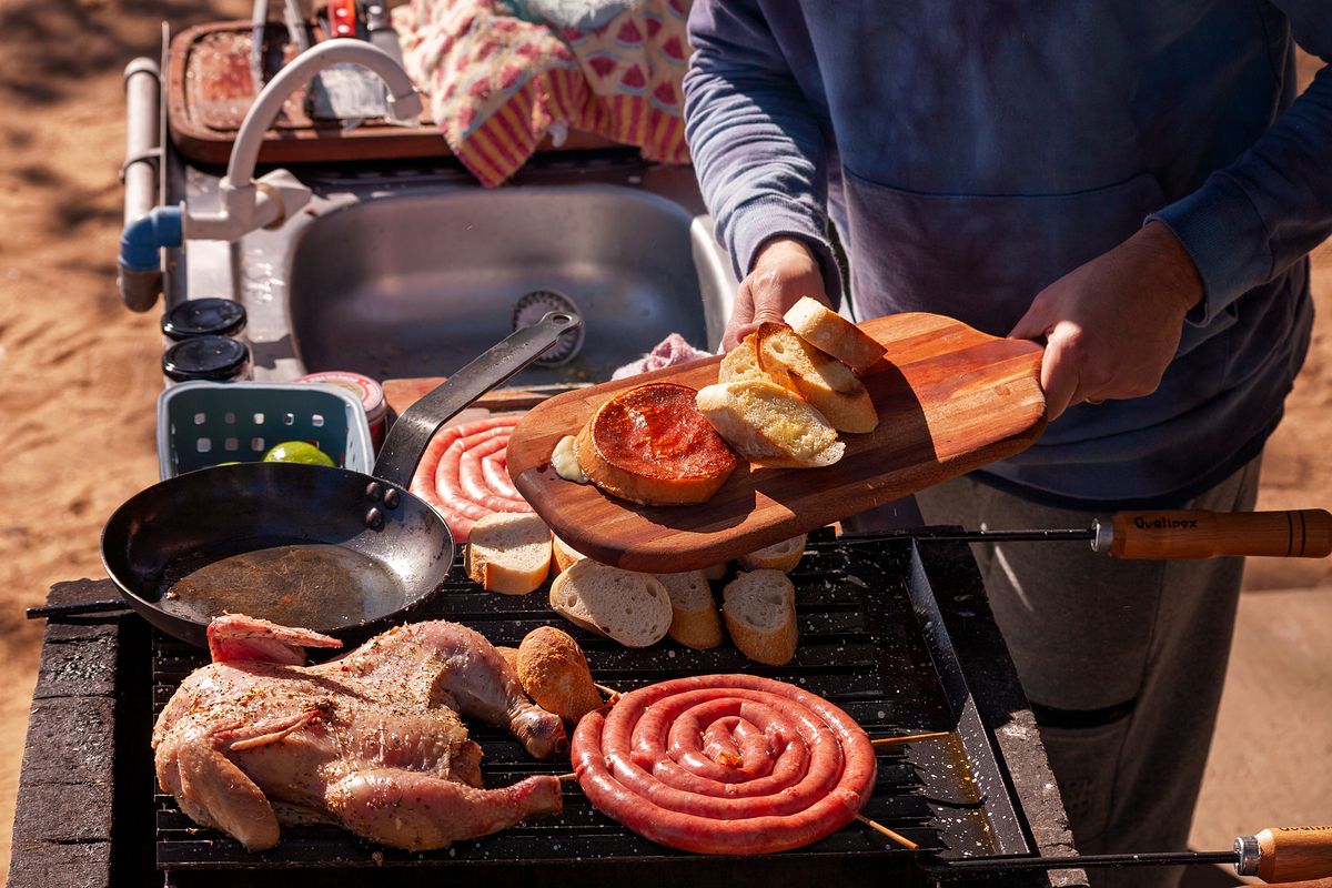 Food grilling over an outdoor barbecue at dusk