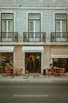 Cozy street cafe in Lisbon, Portugal with traditional tiled architecture, capturing urban life.