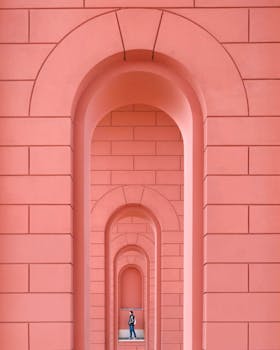 Person walking through a series of vibrant pink arches in Leipzig.