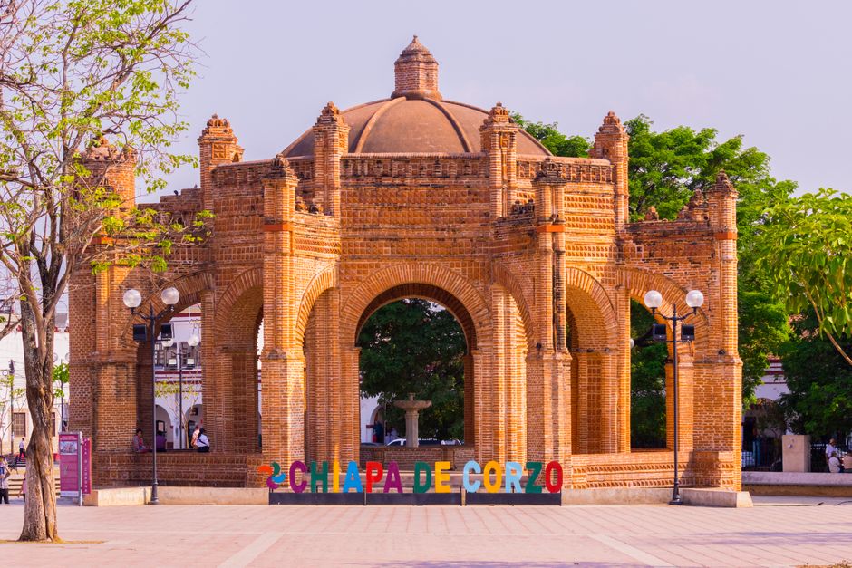 Historic La Pila Fountain in Chiapa de Corzo, Mexico, showcasing intricate brick architecture under a bright sky.