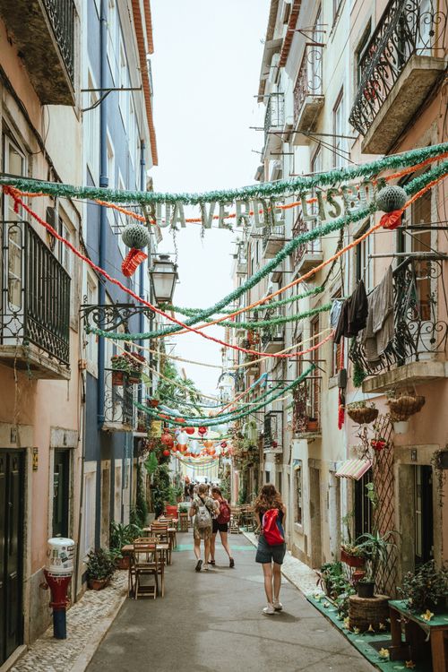 Free Explore a charming Lisbon street adorned with colorful decorations and lively atmosphere. Stock Photo