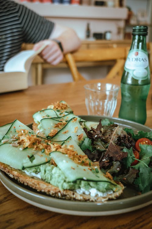 A plate with a sandwich and salad on it