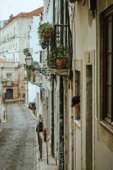 Charming cobblestone street lined with classic buildings and balconies in Lisbon, Portugal.