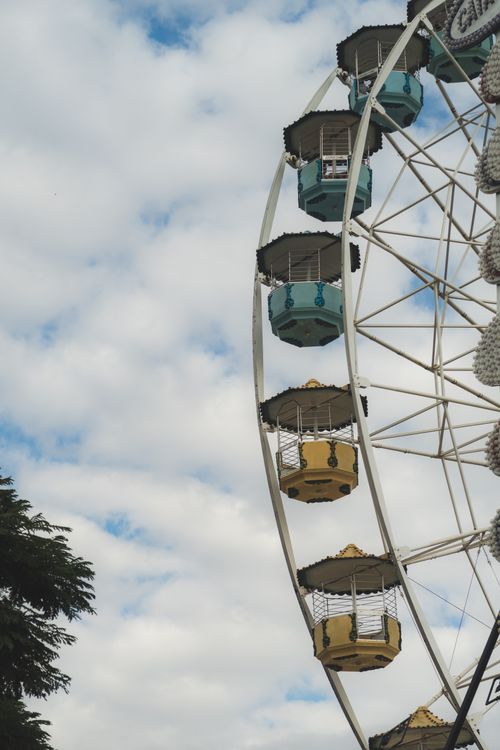 Free A vibrant Ferris wheel in Belo Horizonte framed against a cloudy summer sky. Stock Photo