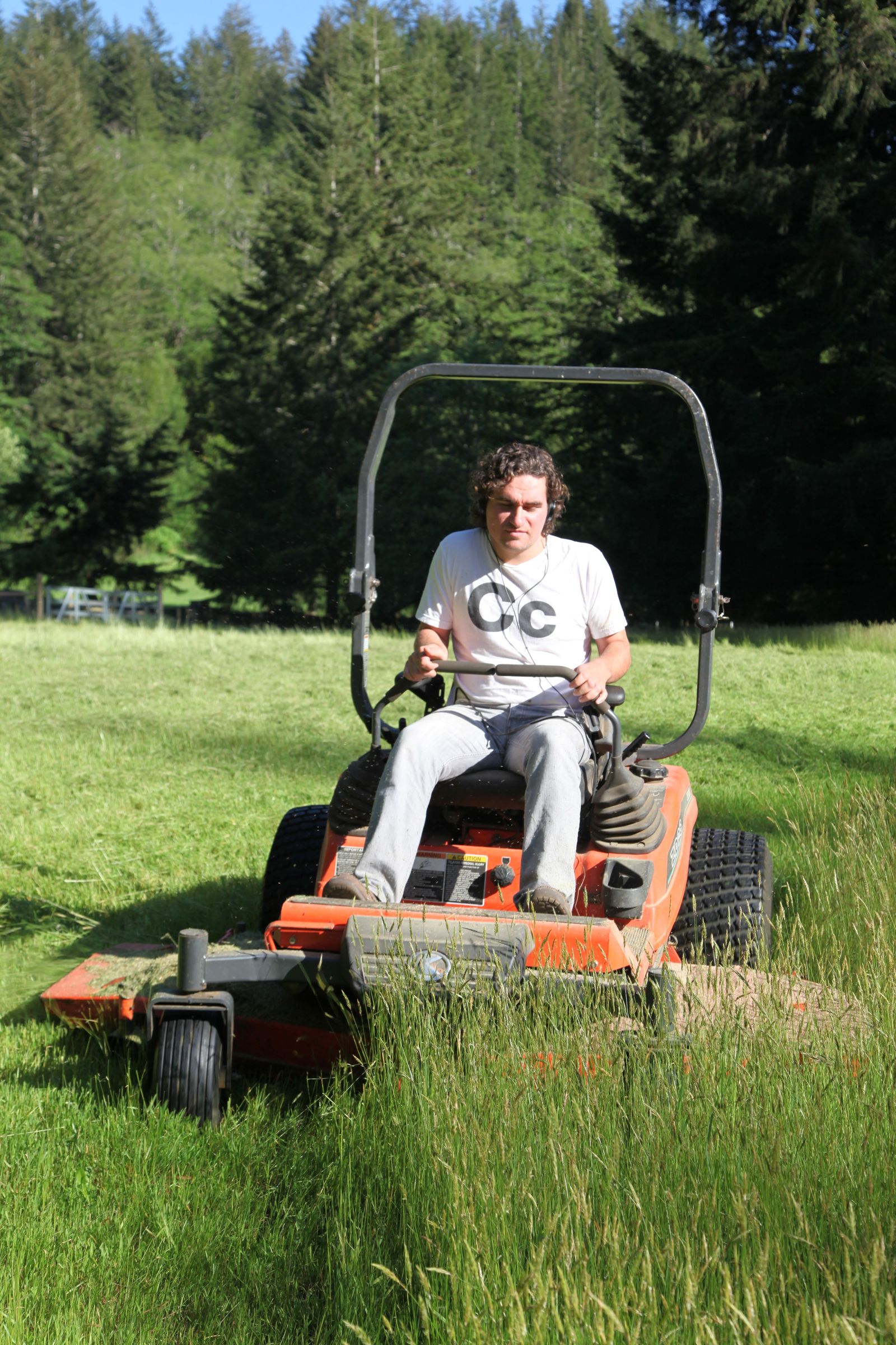 Man in Blue Coveralls Riding a Lawn Mower · Free Stock Photo
