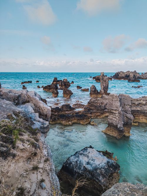Free Stunning view of rugged coastal rocks and clear blue sea under a bright sky, showcasing natural erosion. Stock Photo
