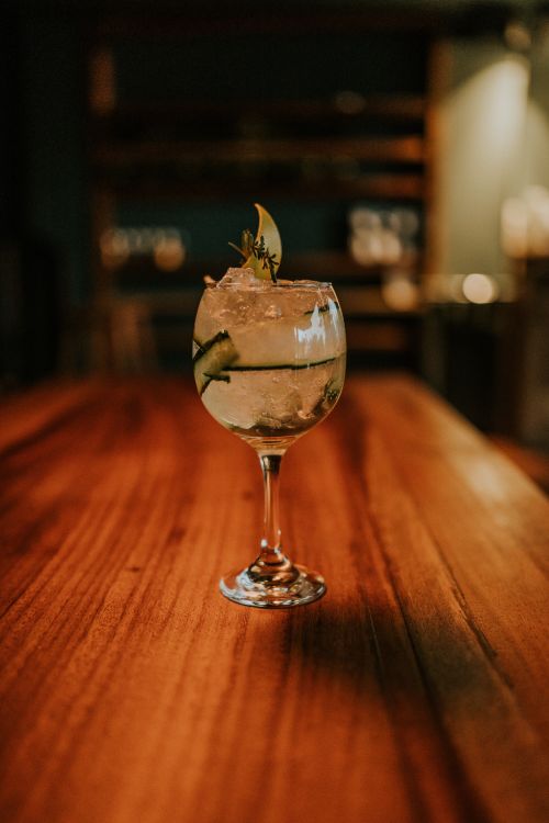 Free A refreshing cocktail served in a glass with garnish on a wooden table in a cozy bar. Stock Photo