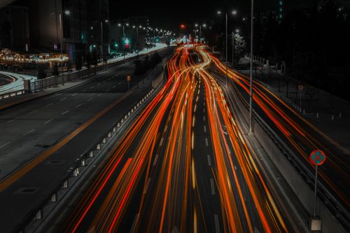 Free Vibrant city highway at night with dynamic light trails from fast-moving vehicles. Stock Photo