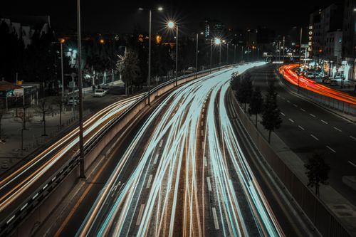 Free Long exposure photo capturing colorful car light trails on a busy city highway at night. Stock Photo
