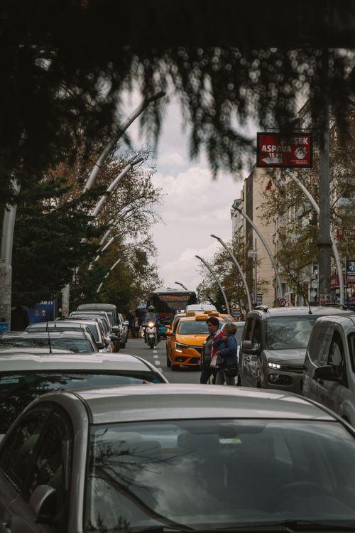 Free A bustling city street in Ankara, Türkiye with cars, motorcycle, and people amidst urban buildings. Stock Photo