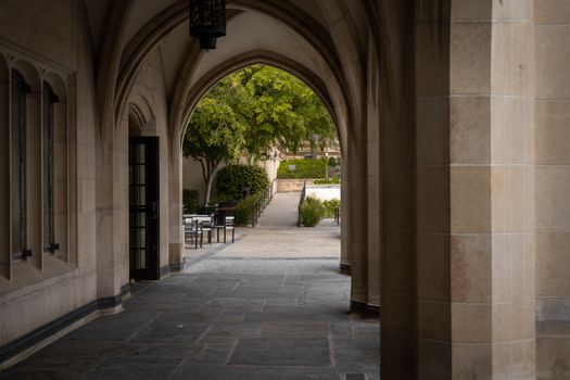 A serene view of an arched walkway leading to a garden area on the UCLA campus in Los Angeles.