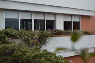 Urban building exterior with flowers adorning windowsills, providing a vibrant summer vibe.