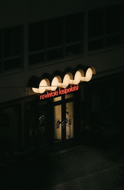 Free A neon-lit restaurant entrance in a dark urban street at night. Stock Photo