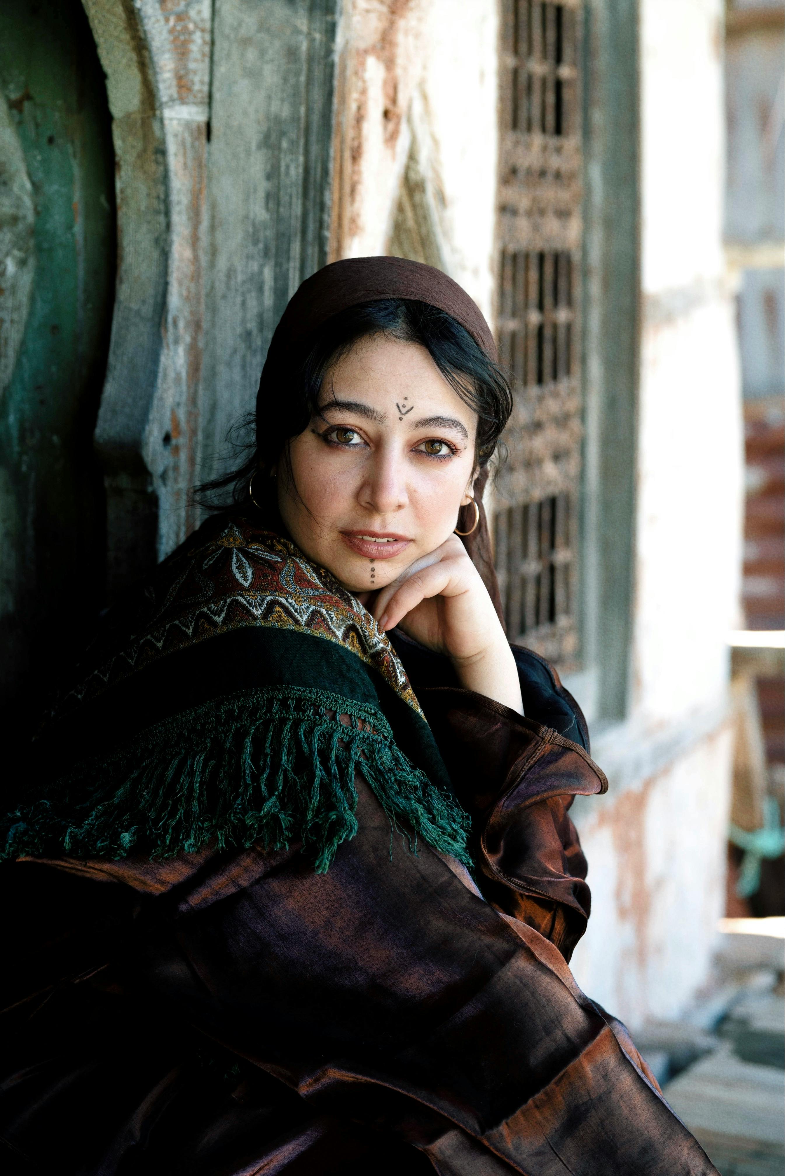 A woman in traditional Indian attire poses thoughtfully, capturing cultural elegance.