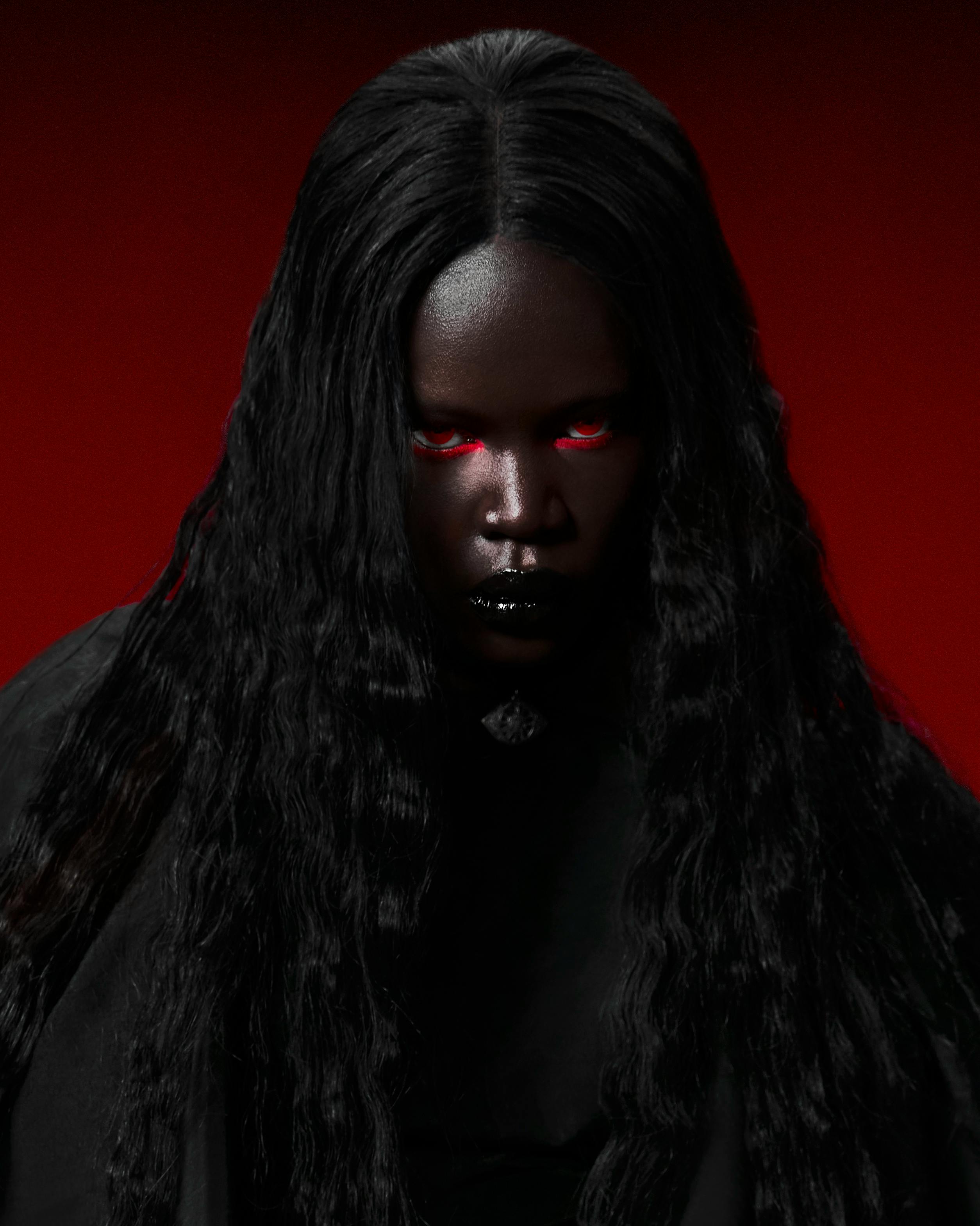 Gothic portrait of a mysterious woman with glowing red eyes and dark hair, evoking a sense of intensity.