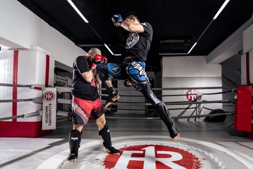 Free Two men engaged in intense kickboxing training inside a professional ring. Stock Photo
