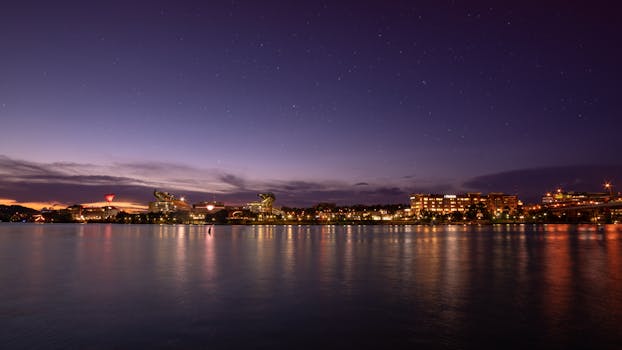 黄昏时分，美丽的城市天际线倒映在水中，星空闪烁