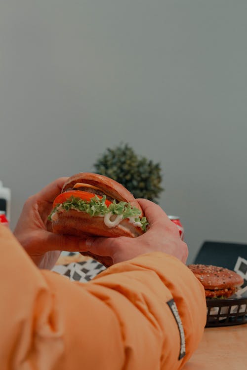 Photo of Hands Holding a Burger