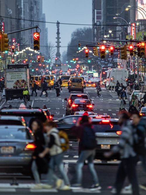 Free A vibrant city street in New York with traffic and pedestrians during evening rush hour. Stock Photo