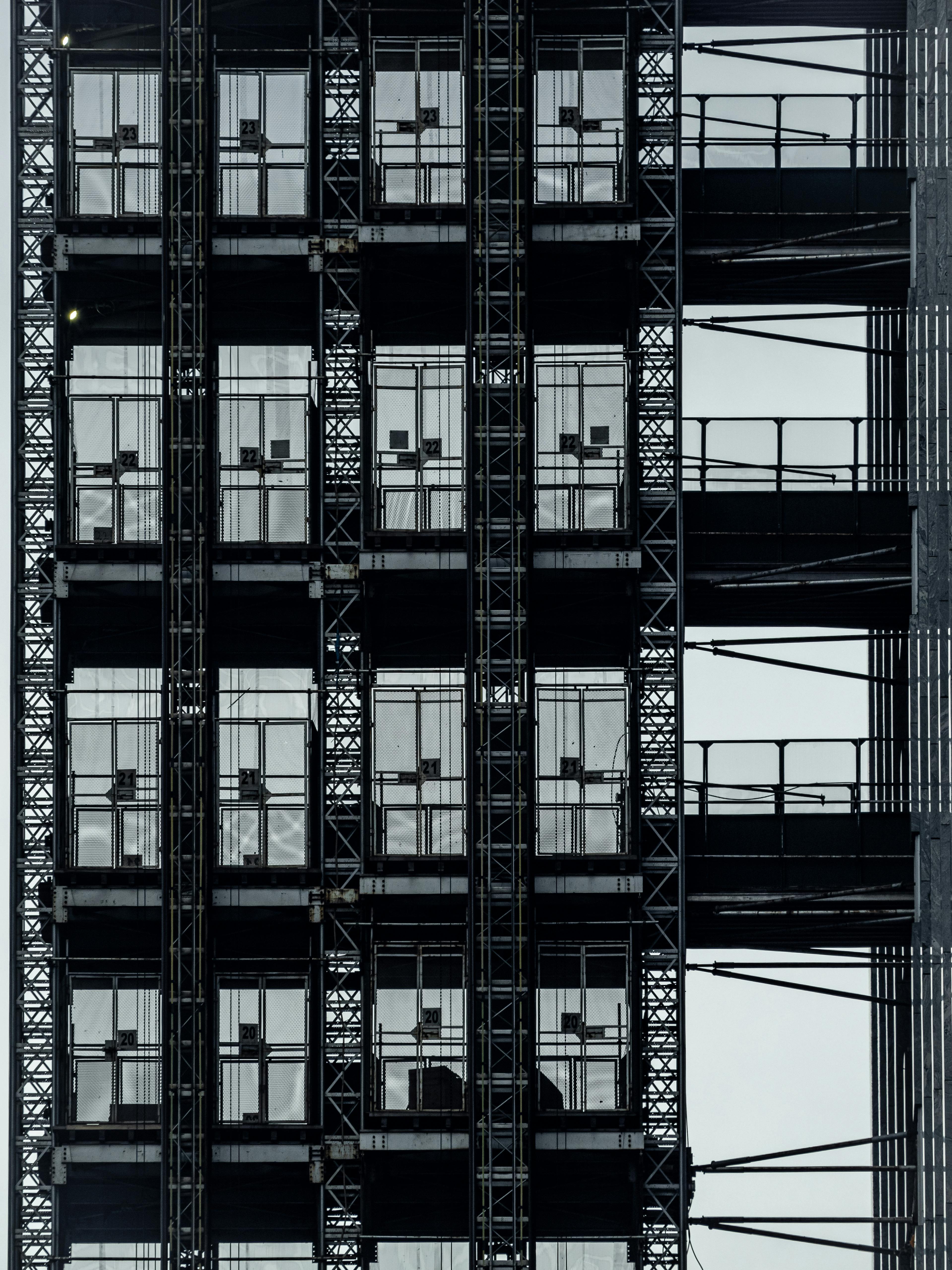Close-up view of modern steel architecture featuring glass elevator shafts in a vertical design.