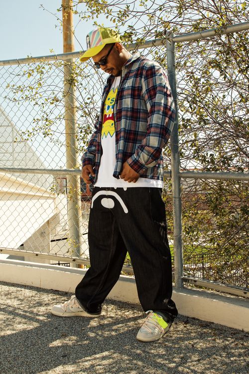 Free Stylish young man in urban streetwear posing outdoors in Long Beach, CA. Stock Photo