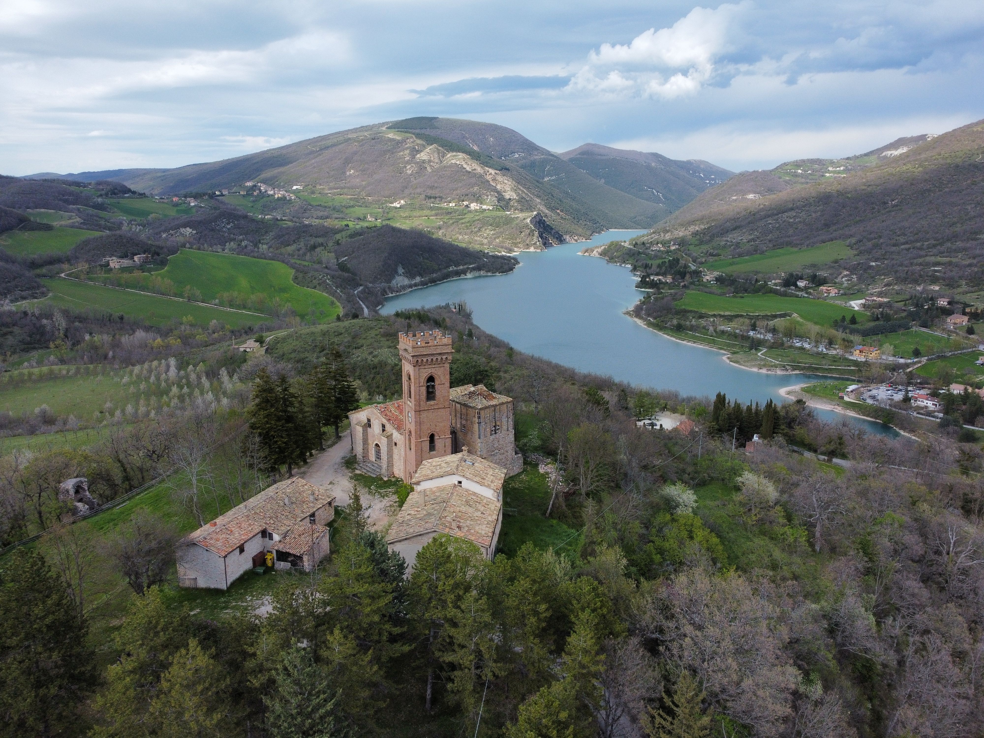 Incredible Helicopter Flight Over Mount Etna Review: Europe's Most Spectacular Volcanic Adventure Review 2026 - Scenic aerial view of a historic castle on a hill overlooking a beautiful lake and lush valley.