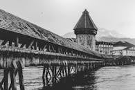 卢塞恩教堂桥的黑白照片以山脉为背景，突出了标志性的塔楼