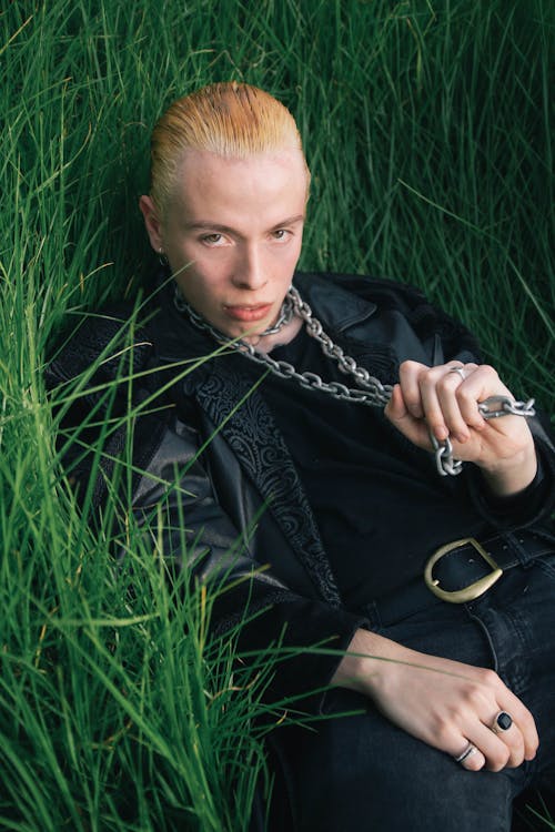 Free Young Man in a Leather Jacket Lying in Grass Stock Photo
