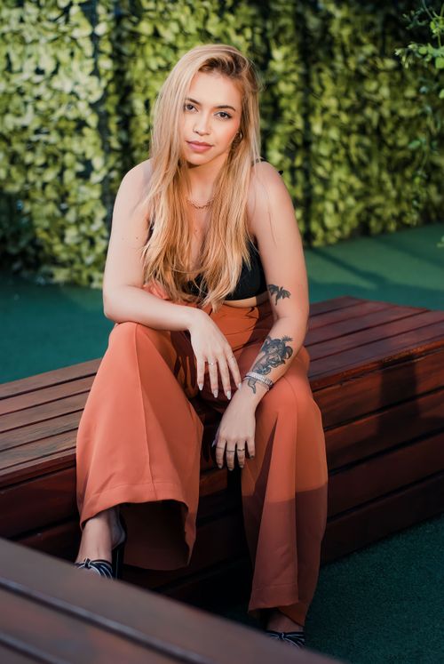 Free Stylish woman with blonde hair posing in wide-leg pants, São Paulo outdoor setting. Stock Photo