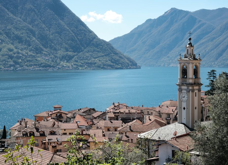 Stunning view of Lake Como from the village with a prominent bell tower against mountainous backdrop.