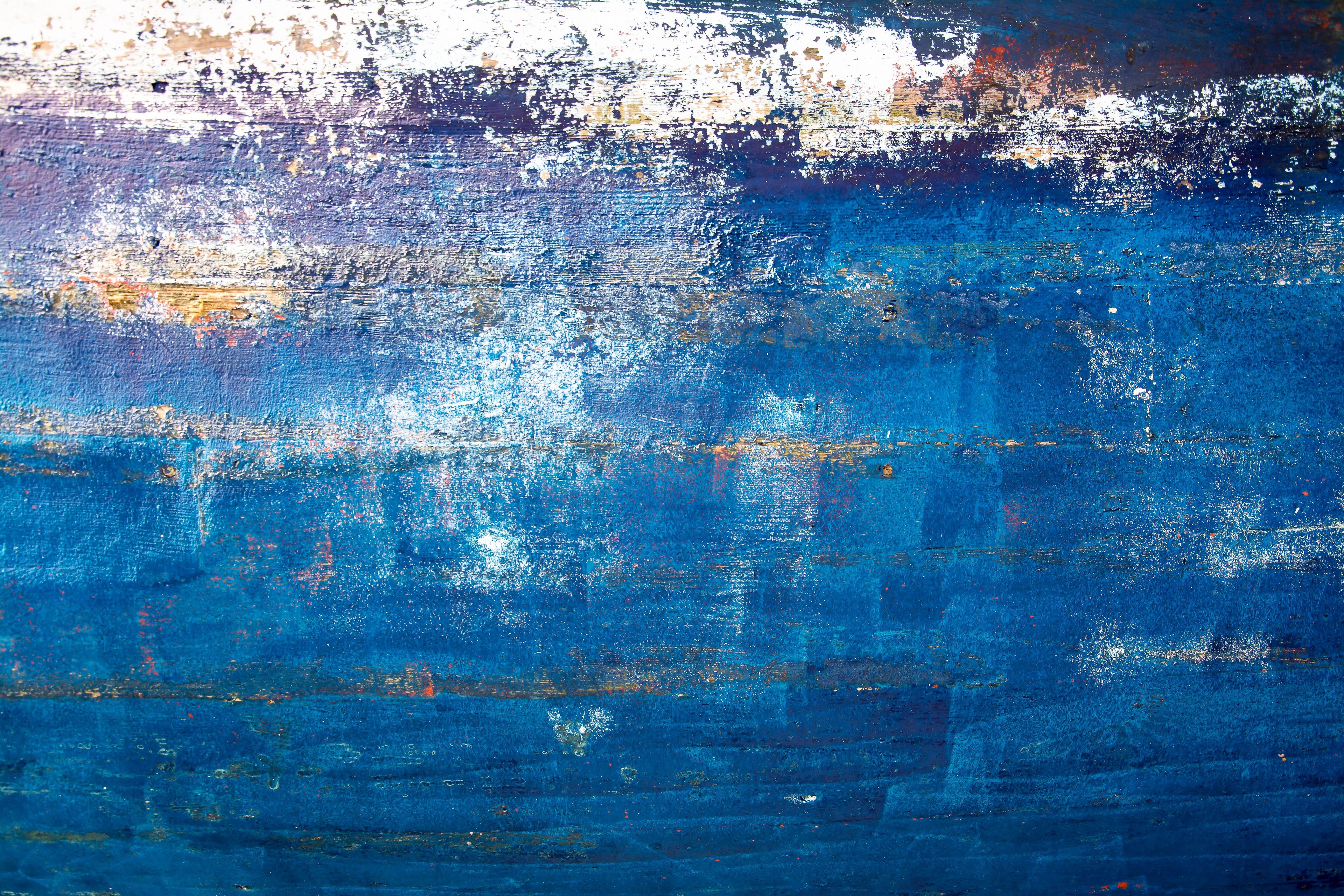 Vibrant abstract texture with blue painted layers and patterns creating a dynamic visual effect.