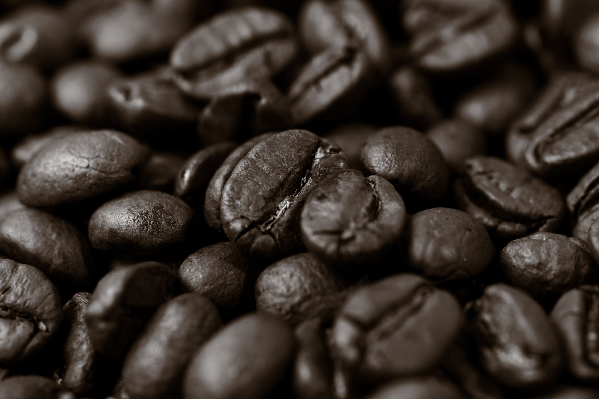 Detailed close-up of roasted coffee beans, highlighting texture and rich brown color.