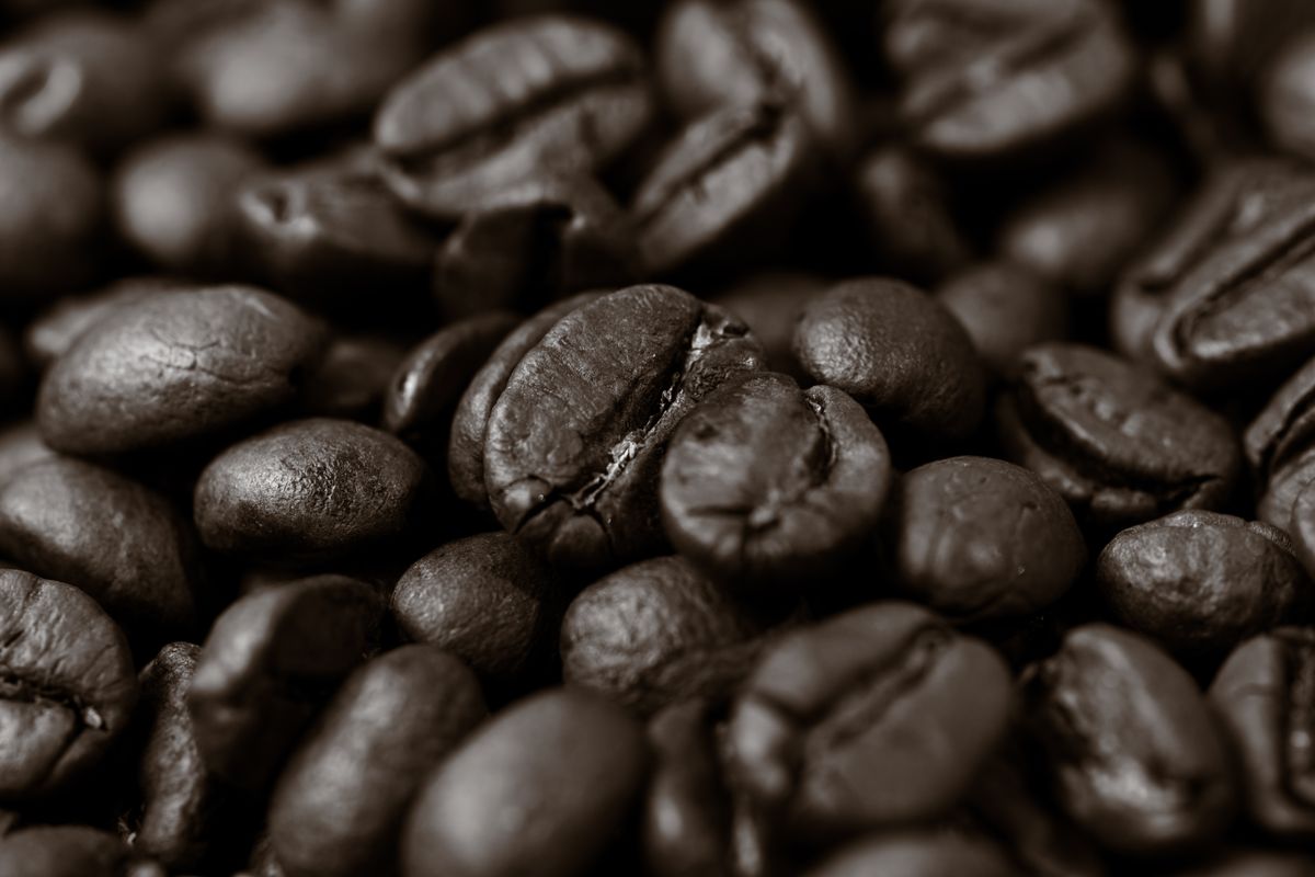 Detailed close-up of roasted coffee beans, highlighting texture and rich brown color.
